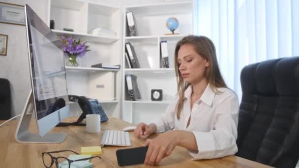 Schöne junge Frau arbeitet im Büro — Stockvideo