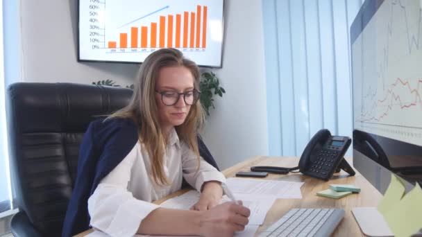 Mooie jonge vrouw werken met documenten in het kantoor — Stockvideo