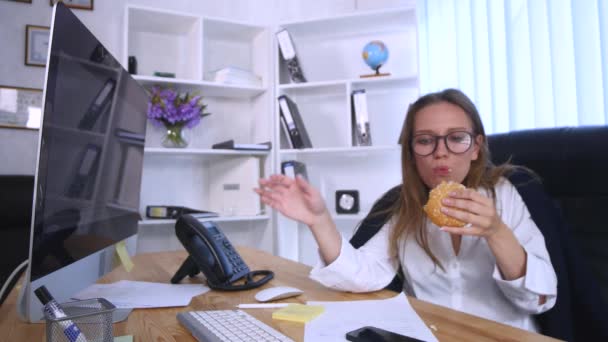 Zaměstnaná žena mluví po telefonu přitom burger — Stock video