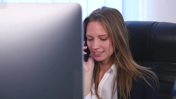 Una giovane donna d'affari attraente che parla al telefono in ufficio e scappa dall'ufficio. vicino — Video Stock