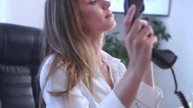 Bacaklarını ofiste tabloda ile telefonda konuşurken genç çekici işkadını