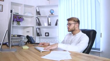 Genç adam ofiste çalışıyor.