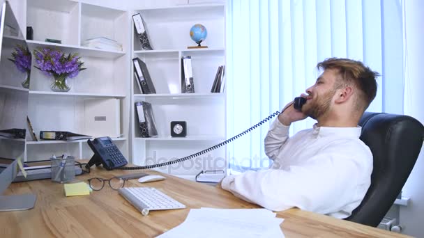 Alegre hombre en la oficina contestando el teléfono — Vídeos de Stock