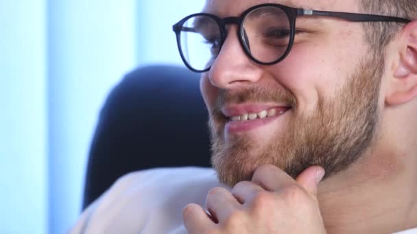 Portrait of a Bearded Young Man Wearing Glasses Sitting in His Office Working on a Computer. Computer Screen Reflects in His Glasses — Stock Video