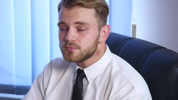 Portrait d'un jeune homme barbu assis dans son bureau travaillant sur un ordinateur — Video