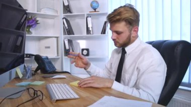 Bilgisayarda çalışarak ve Notlar not defterinde Office masada otururken yapma genç iş adamı