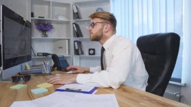 Bilgisayarda çalışarak ve Office Not defterinizdeki notlar yapma genç iş adamı