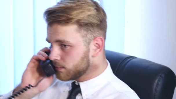 Un uomo allegro in ufficio che risponde al telefono. primo piano — Video Stock