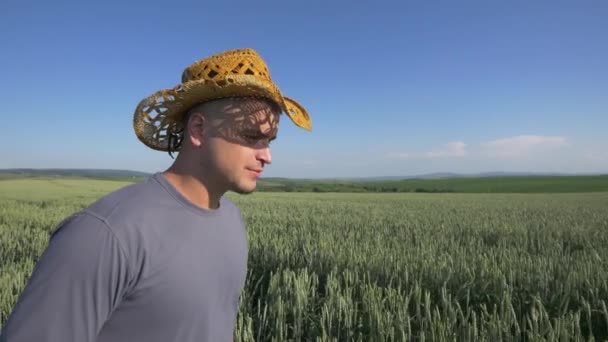 Menschen, Getränke und Alkoholkonzept - Nahaufnahme eines jungen Mannes, der Bier aus einem Glas über einem Getreidefeld trinkt — Stockvideo