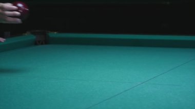 Kız el topu Bilardo masanın üzerine koyar. Büyük kırmızı bilardo topu ön planda