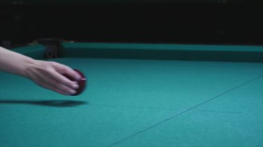 Kız el topu Bilardo masanın üzerine koyar. Büyük kırmızı bilardo topu ön planda