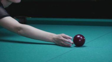 el kız Top Bilardo masanın üzerine koyar. Büyük kırmızı bilardo topu ön planda