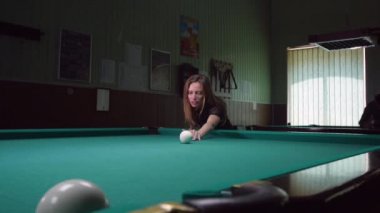 Genç kadın bilardo oyunu oynarken