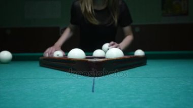 Kız hazırlanıyor topları için oyun. Kız bilardo topları setleri ve plastik üçgen kaldırır. Başlama pozisyonu içinde bilardo topları. Atış izleme, yakın çekim
