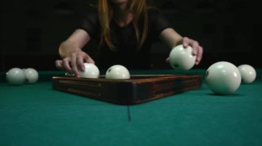 Kız hazırlanıyor topları için oyun. Kız bilardo topları setleri ve plastik üçgen kaldırır. Başlama pozisyonu içinde bilardo topları. Atış izleme, yakın çekim