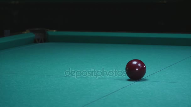 Девушка кладет мяч на бильярдный стол. Большой красный бильярдный шар на переднем плане — стоковое видео