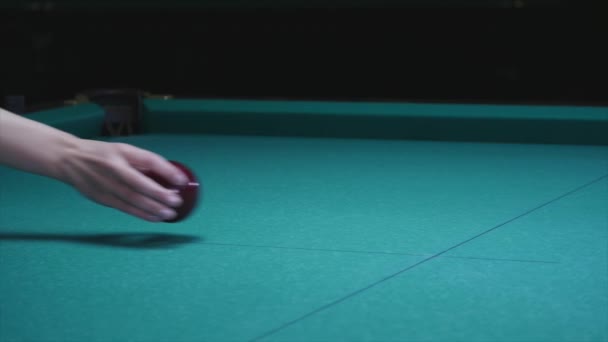 Girl hand puts ball on the billiard table. Big red billiard ball in the foreground — Stock Video