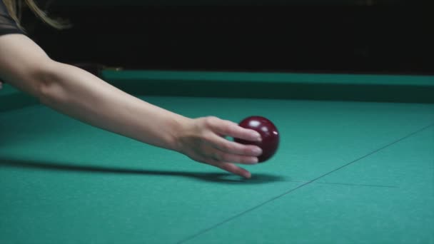 Chica de la mano pone bola en la mesa de billar. Gran bola de billar rojo en primer plano — Vídeos de Stock
