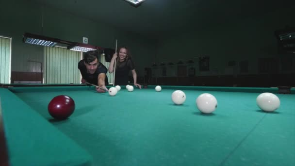 A beautiful girl and young man playing billiards — Stock Video