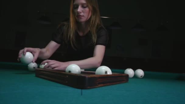 La fille qui prépare les couilles pour jouer. Fille fixe des boules de billard et enlève triangle en plastique. Balles de billard en position de départ. Plan de suivi, gros plan — Video