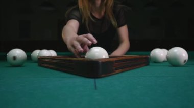 Kız hazırlanıyor topları için oyun. Kız bilardo topları setleri ve plastik üçgen kaldırır. Başlama pozisyonu içinde bilardo topları. Atış izleme, yakın çekim