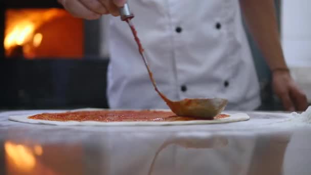 Close-up van de tomatensaus is over de pizza deeg besmeurd — Stockvideo