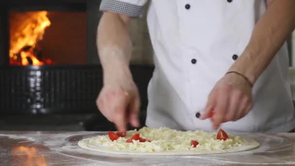 Cuire les mains dans la cuisine en mettant les ingrédients sur la pizza. Concept de pizza. Production et livraison de denrées alimentaires — Video