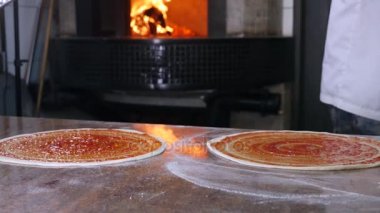 Aşçı mutfakta, pizzanın malzemelerini koyuyor. Pizza konsepti. Gıda üretimi ve teslimatı