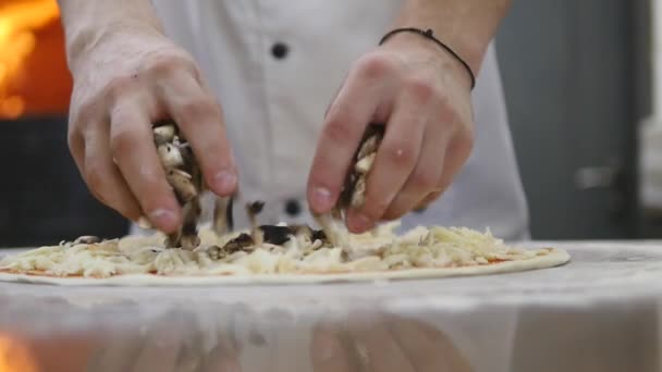 Cucina le mani in cucina mettendo gli ingredienti sulla pizza. Concetto pizza. Produzione e consegna di prodotti alimentari — Video Stock