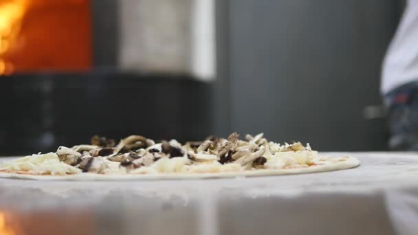 Kockar händer i köket att sätta ingredienser på pizza. Pizza-konceptet. Produktion och leverans av mat — Stockvideo