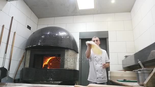 Повара вращают тесто для пиццы в воздухе — стоковое видео