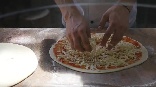 Cucina le mani in cucina mettendo gli ingredienti sulla pizza. Concetto pizza. Produzione e consegna di prodotti alimentari — Video Stock