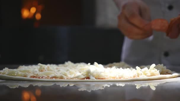 Cucina le mani in cucina mettendo gli ingredienti sulla pizza. Concetto pizza. Produzione e consegna di prodotti alimentari — Video Stock