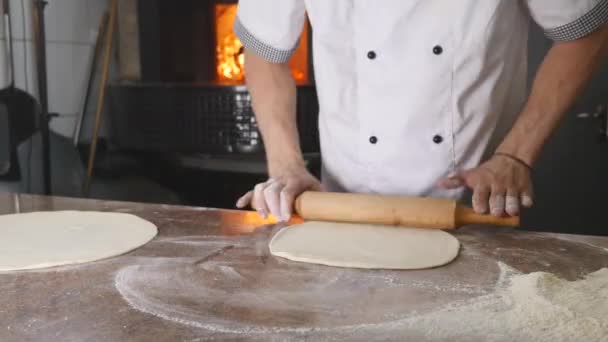 The chefs hands roll the dough into pizza — Stock Video