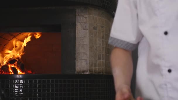 Шеф-повар кладет пиццу в кирпичную печь — стоковое видео