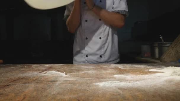 Chef-koks draaien pizza deeg in de lucht — Stockvideo