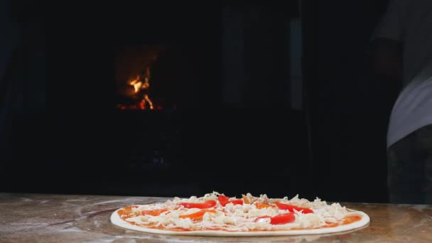 Cocina las manos en la cocina poniendo los ingredientes en la pizza. Concepto de pizza. Producción y entrega de alimentos — Vídeo de stock