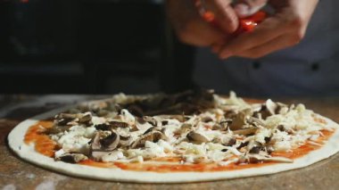 Malzemeler pizza üzerine koyarak mutfakta aşçılar eller. Pizza kavramı. Üretim ve teslimat gıda