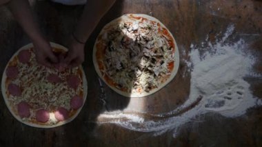 Malzemeler pizza üzerine koyarak mutfakta aşçılar eller. Pizza kavramı. Üretim ve teslimat yiyecek. Üstten Görünüm