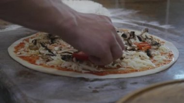 Malzemeler pizza üzerine koyarak mutfakta aşçılar eller. Pizza kavramı. Üretim ve teslimat gıda