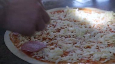 Malzemeler pizza üzerine koyarak mutfakta aşçılar eller. Pizza kavramı. Üretim ve teslimat gıda