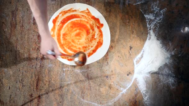 Vista superior do molho de tomate é manchado sobre a massa de pizza — Vídeo de Stock