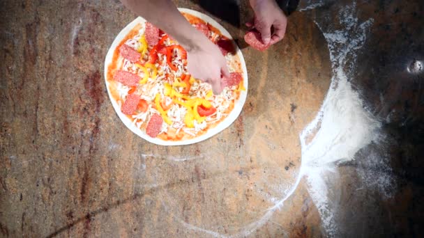 Köche in der Küche legen die Zutaten auf die Pizza. Pizza-Konzept. Produktion und Lieferung von Lebensmitteln. Ansicht von oben — Stockvideo