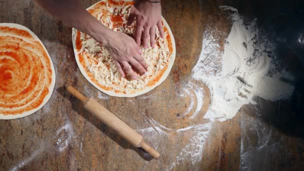 Cucina le mani in cucina mettendo gli ingredienti sulla pizza. Concetto pizza. Produzione e consegna di prodotti alimentari. Vista dall'alto — Video Stock