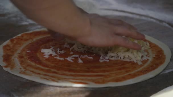 Cucina le mani in cucina mettendo gli ingredienti sulla pizza. Concetto pizza. Produzione e consegna di prodotti alimentari — Video Stock