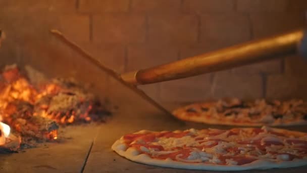 Выпечка пиццы в дровяной печи — стоковое видео