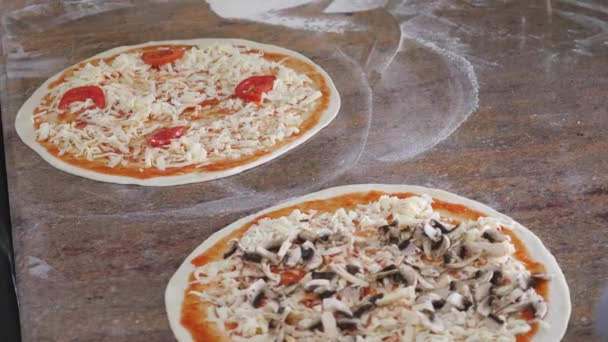 Cocina las manos en la cocina poniendo los ingredientes en la pizza. Concepto de pizza. Producción y entrega de alimentos. De cerca. — Vídeos de Stock