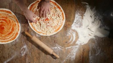 Malzemeler pizza üzerine koyarak mutfakta aşçılar eller. Pizza kavramı. Üretim ve teslimat yiyecek. Üstten Görünüm