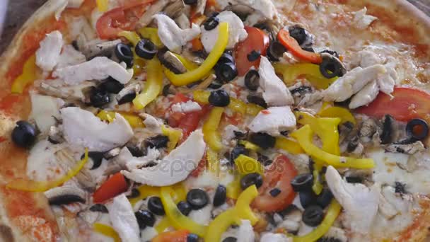 Піца на тарілці дерев'яна дошка Ручне різання з різаком для піци. вид зверху. крупним планом — стокове відео