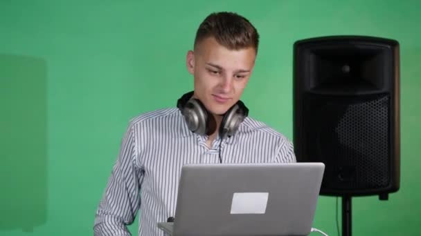 DJ olha para o laptop e dança — Vídeo de Stock